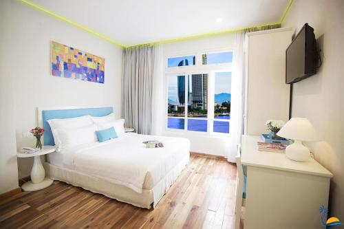 een slaapkamer met een bed en een groot raam bij Cọ Xanh Hotel in Da Nang