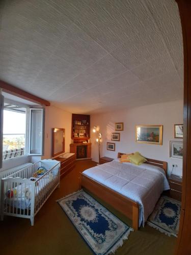 a bedroom with a bed and a crib in it at Nonna Anita in Castelveccana