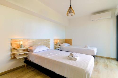two beds in a room with white walls at SELECT'soHOME - Appartement face à la mer avec piscine à Bormes-les-mimosas - CAPNAT-C04 in Bormes-les-Mimosas