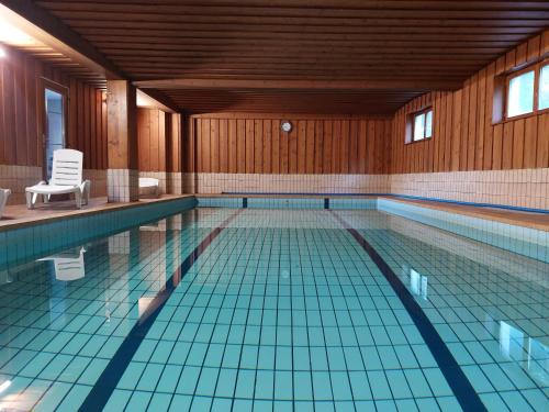 a swimming pool with two chairs and aermottermott at Hotel-Spa & Restaurant Logis Domaine Langmatt in Murbach