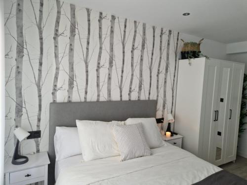 Schlafzimmer mit einem Bett mit Bäumen an der Wand in der Unterkunft My home in Gijón Apartamento - VUT4494AS in Gijón
