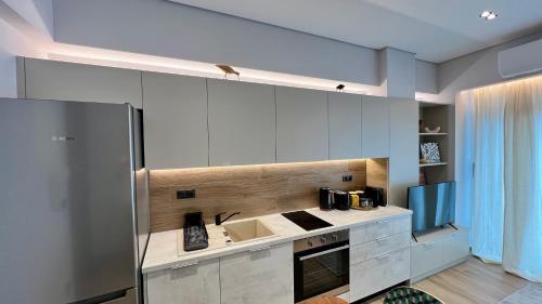 a kitchen with white cabinets and a sink at Jack, 2 people, renovated stylish apartment in Athens