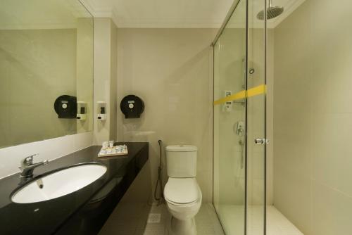 a bathroom with a toilet and a sink and a shower at New Cape Inn in Singapore