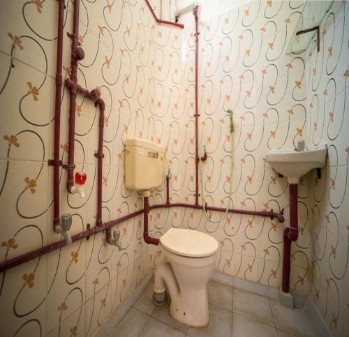 ein Bad mit einem WC und einem Waschbecken in der Unterkunft Sacar Guest House in Puducherry