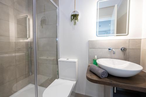 a bathroom with a sink and a glass shower at Morecambe Bay Studio Flats Free Parking Beach Front in Morecambe