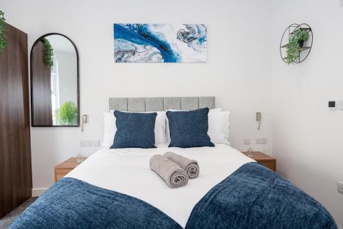 a bedroom with a large bed with blue pillows at Morecambe Bay Studio Flats Free Parking Beach Front in Morecambe
