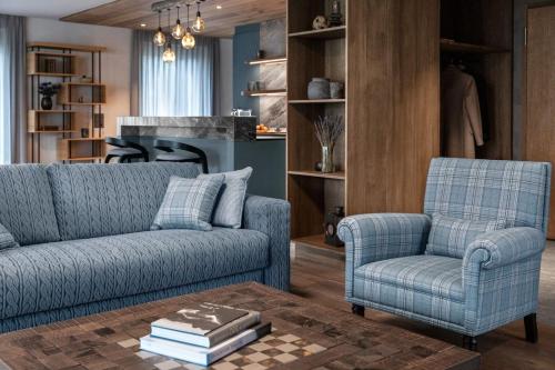 a living room with two blue chairs and a table at Tschuggen Grand Hotel - The Leading Hotels of the World in Arosa