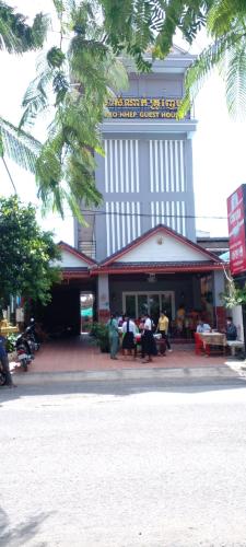 a building with people sitting at tables in front of it at Kro Nhep Guesthouse in Kampot