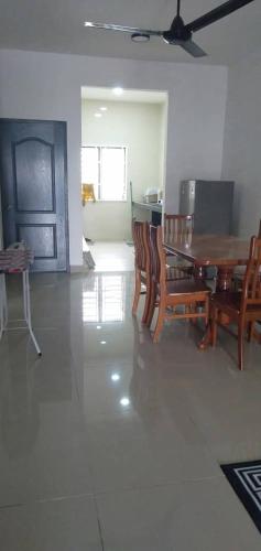 - une salle à manger avec une table et des chaises en bois dans l'établissement Faizeen Homestay, à Kuala Kerai