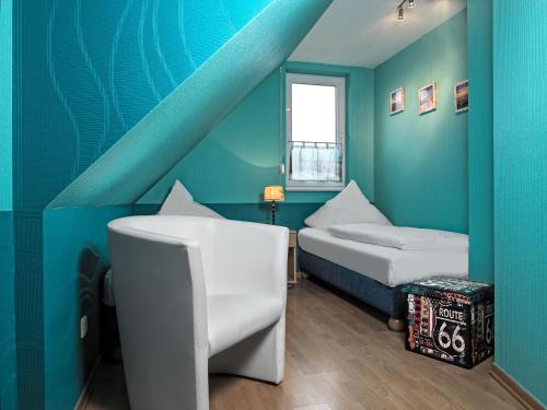Zimmer mit 2 Betten und blauer Wand in der Unterkunft FH Harmonie in Kaltenhof