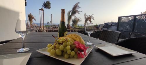 サンミゲル・デ・アボナにあるPromenade Paradise Apartmentのブドウ皿とワイングラスのテーブル