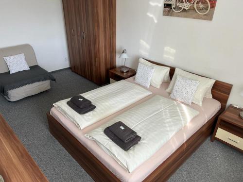 a bedroom with a large bed with two towels on it at Parkhotel Smržovka in Smržovka