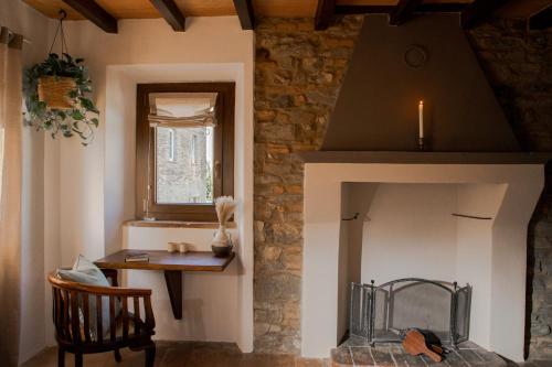 a room with a fireplace with a table and a chair at Dimidium in Canossa