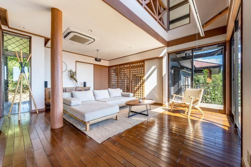 ein Wohnzimmer mit einem weißen Sofa und einem Tisch in der Unterkunft プライベートリゾート碧海 in Okawa