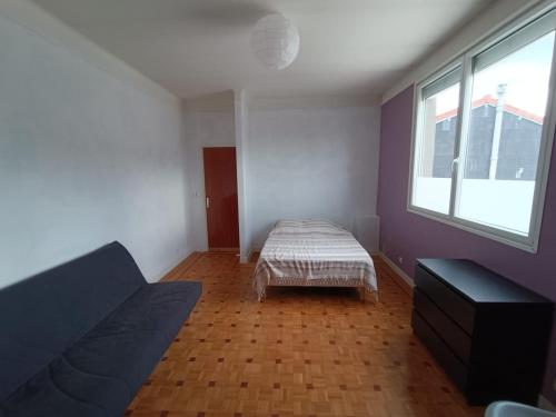 a living room with a bed and a window at Appartement spacieux in Montreuil