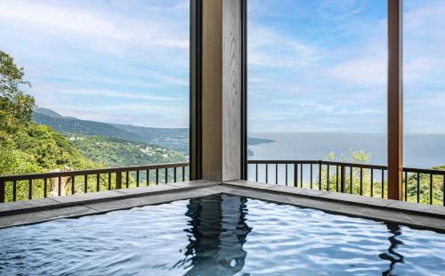 a swimming pool with a view of the ocean at プライベートリゾート碧海 in Okawa