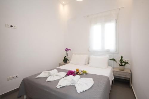 um quarto com uma cama com paredes brancas e uma janela em Spilia Apartments & Suites Mykonos em Agrari