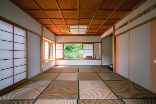 ein leeres Zimmer mit einem Fenster und Fliesenboden in der Unterkunft プライベートリゾート碧海 in Okawa