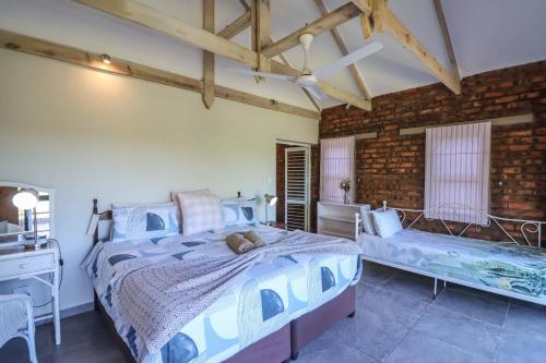 a bedroom with a large bed and a brick wall at Relaxation in KwaDukuza