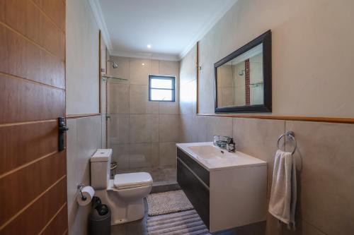 a bathroom with a sink and a toilet and a mirror at Relaxation in KwaDukuza