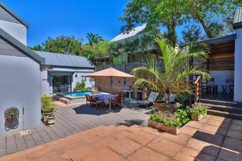 a patio with a table and chairs and an umbrella at Relaxation in KwaDukuza