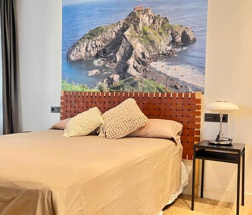 a bedroom with a bed with a painting on the wall at SMALL LUX BEACHCITY close to METRO in Bilbao