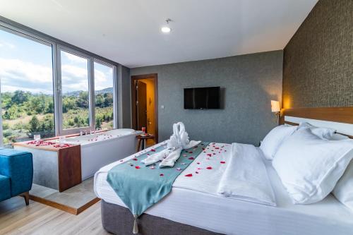 a bedroom with a tub and a bed with roses on it at Tilya Resort Hotel in Trabzon