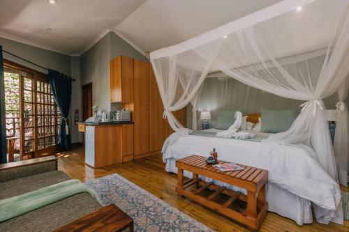a bedroom with a large bed with a canopy at Beetleloop Guest House in Nelspruit