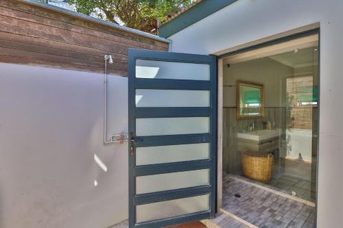 eine Tür, die zu einem Bad mit einem Waschbecken führt in der Unterkunft Relaxation in KwaDukuza
