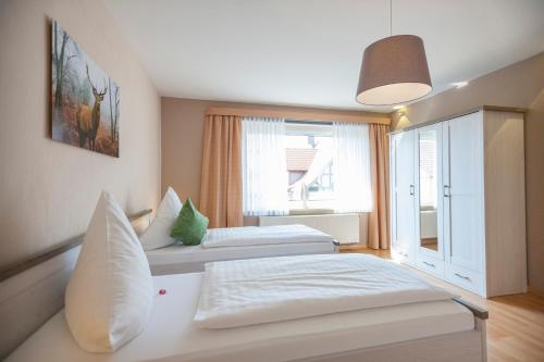 una camera d'albergo con due letti e una finestra di Ferienhaus OG1 "Westerwald Blick" a Martinfeld