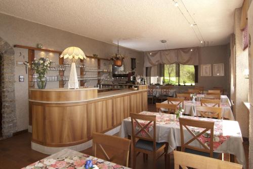 a restaurant with tables and chairs and a bar at Hotel Mariano in Gargnano
