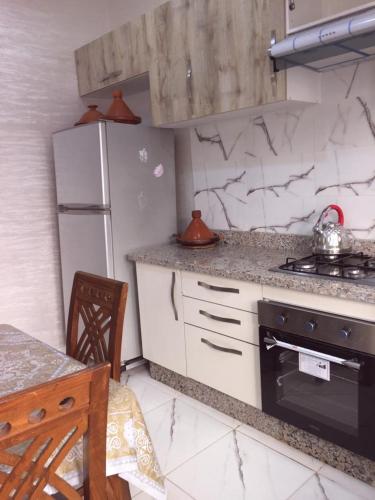 a kitchen with a stove and a refrigerator at Airport M V chambre stay in Deroua