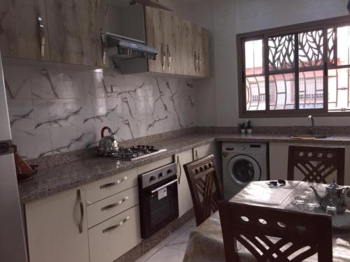 a kitchen with a sink and a stove top oven at Airport M V chambre stay in Deroua