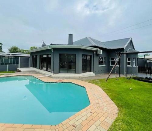 a house with a large swimming pool in the yard at 2 on Haig Accommodation, Selbourne, East London in East London