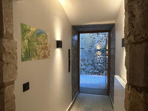 a hallway with a door leading to a stone wall at Domaine Cysaril - Gite 4 étoiles in Talissieu