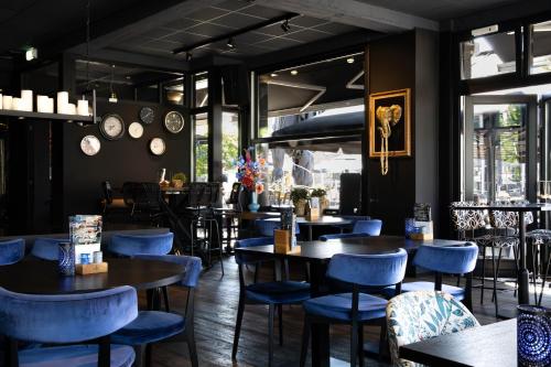 un ristorante con sedie blu, tavoli e finestre di Mart9 City Loft a Zevenbergen
