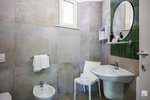 a bathroom with a sink and a mirror at Villaggio Baia D'Ercole in Capo Vaticano