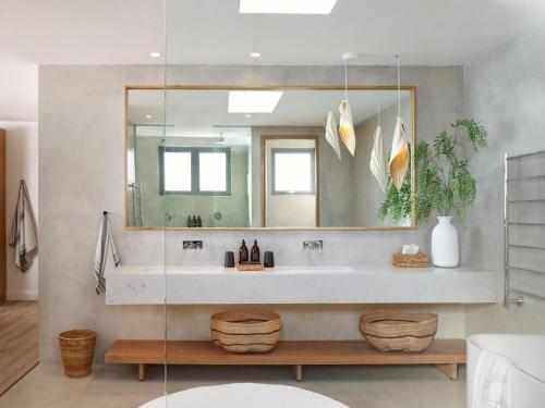 La salle de bains est pourvue d'un lavabo et d'un miroir. dans l'établissement Walkers Beach, à Plettenberg Bay