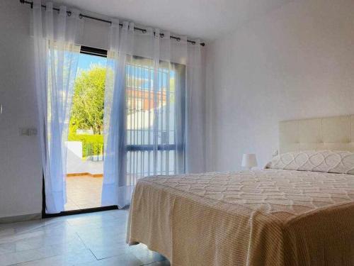 a bedroom with a bed and a sliding glass door at Acogedora casa con terraza y chimenea in Marbella