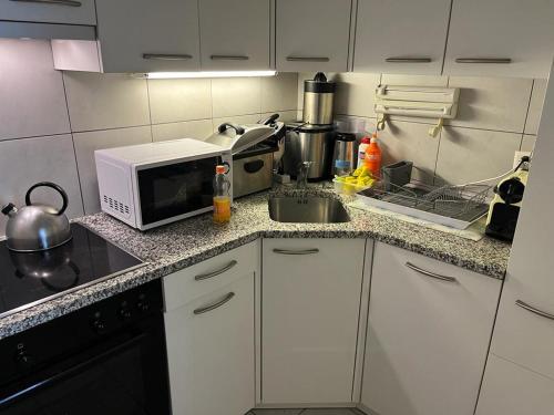 a kitchen with a microwave and a sink at Fortuna 403 in Leukerbad