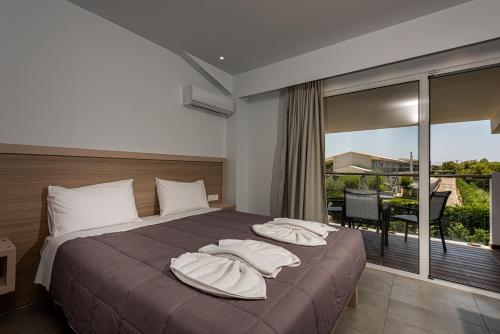 um quarto com uma cama com almofadas e uma varanda em Caretta Island em Kalamaki