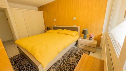 a bedroom with a bed with a yellow blanket at Fortuna 403 in Leukerbad