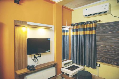 um quarto com uma televisão de ecrã plano e uma janela em Star VIP-Inn Kolkata Airport em Calcutá