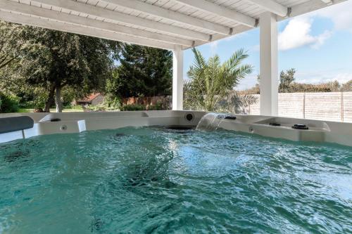 una bañera de hidromasaje en un patio con una fuente de agua en B&B Maison La Belle, en Zoutleeuw