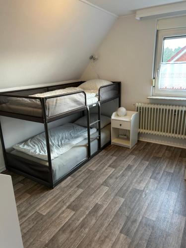 Cette chambre comprend 2 lits superposés et du parquet. dans l'établissement Ferienhaus Angela, à Dankern