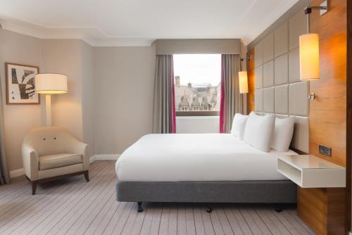 a hotel room with a bed and a chair at Hilton Cambridge City Centre in Cambridge