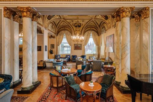 a lobby with columns and tables and chairs at Grand Hotel Villa Serbelloni - A Legendary Hotel in Bellagio