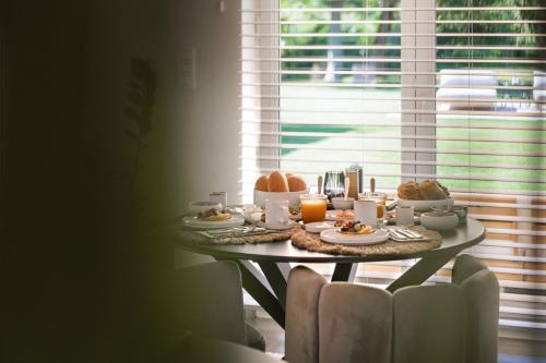 a table with breakfast food and orange juice on it at Maison La Belle Cosy 2-bedroom house with jacuzzi & airco in Zoutleeuw