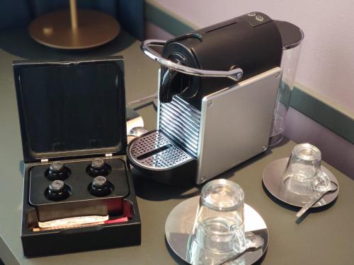 una mesa con ordenador portátil y platos y gafas en Alice Hotel, en Budapest