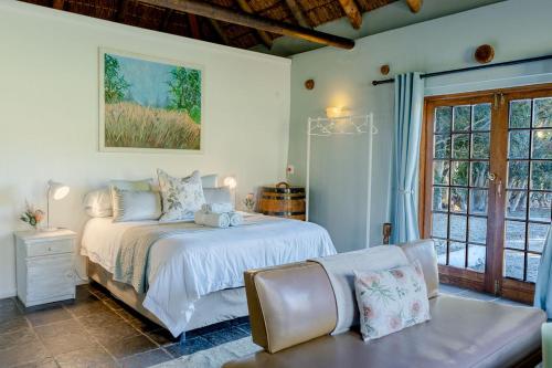 a white bedroom with a bed and a couch at Oude Compagnies Post in Tulbagh